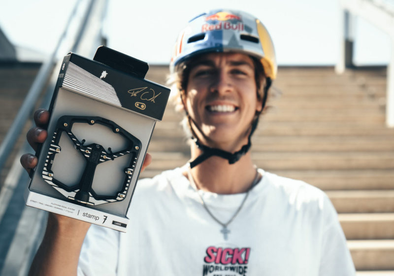 fabio wibmer holding his signature edition flat pedals from crank brothers