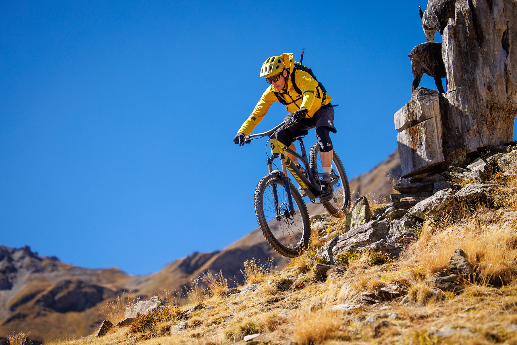 rider dropping off rocks on scott genius mountain bike