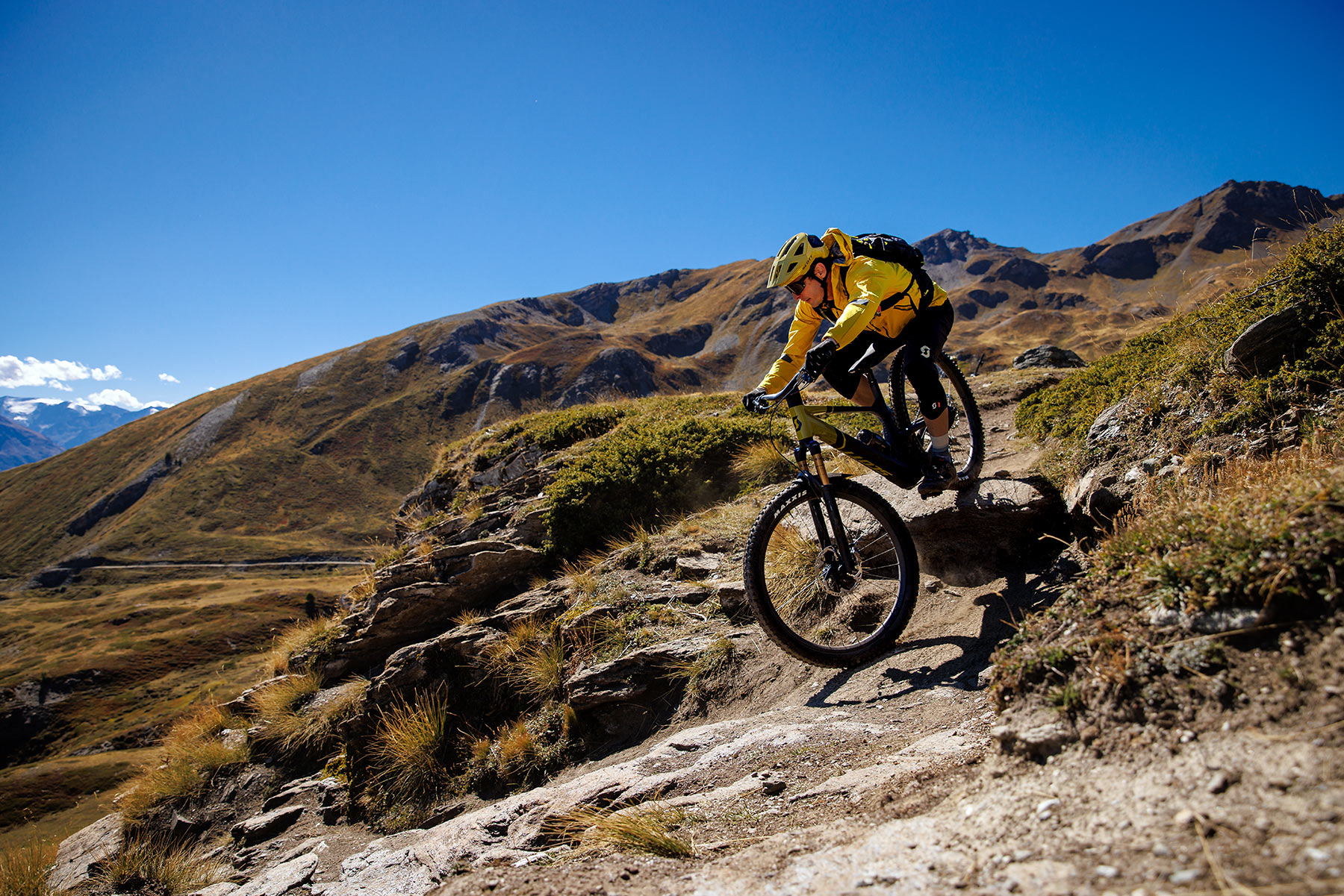 rider dropping off rocks on new scott genius mountain bike