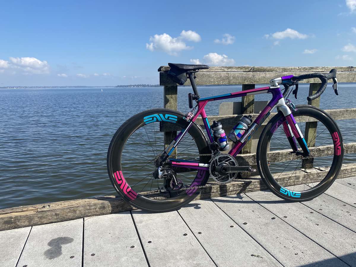 bikerumor pic of the day a time road bike is on a wood pier overlooking a large lake, there are a few fluffy clouds in the sky and the sun is high