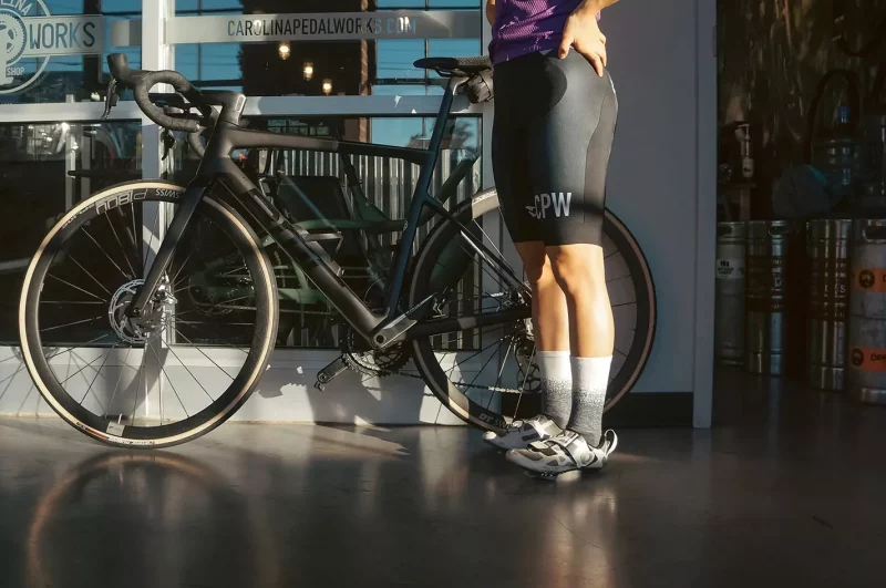 cyclist wearing Defeet wooleator pro cycling socks at a brewery