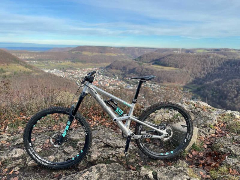 bikerumor pic of the day a mountain bike atop a peak overlooking a village in a valley