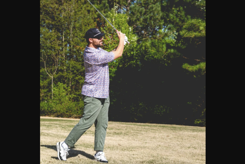 a man golfing in a handup shirt