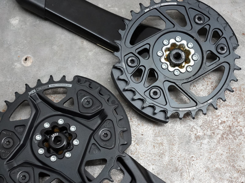 closeup of XX and XO chainring and integrated bash guards on T-Type cranksets