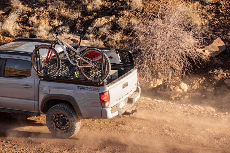 truck with a rear rack carrying a mountain bike and camping equipment