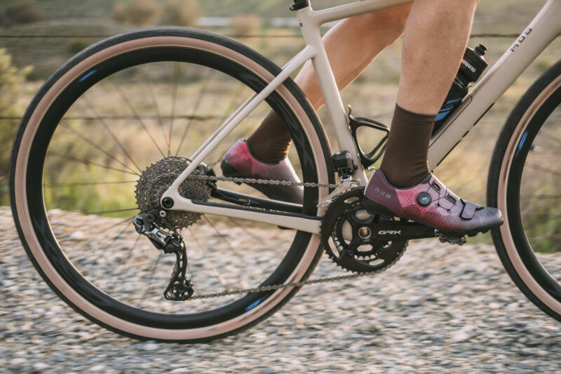 A cyclist riding a gravel bike in Shimano's flint hills edition RX8 shoes