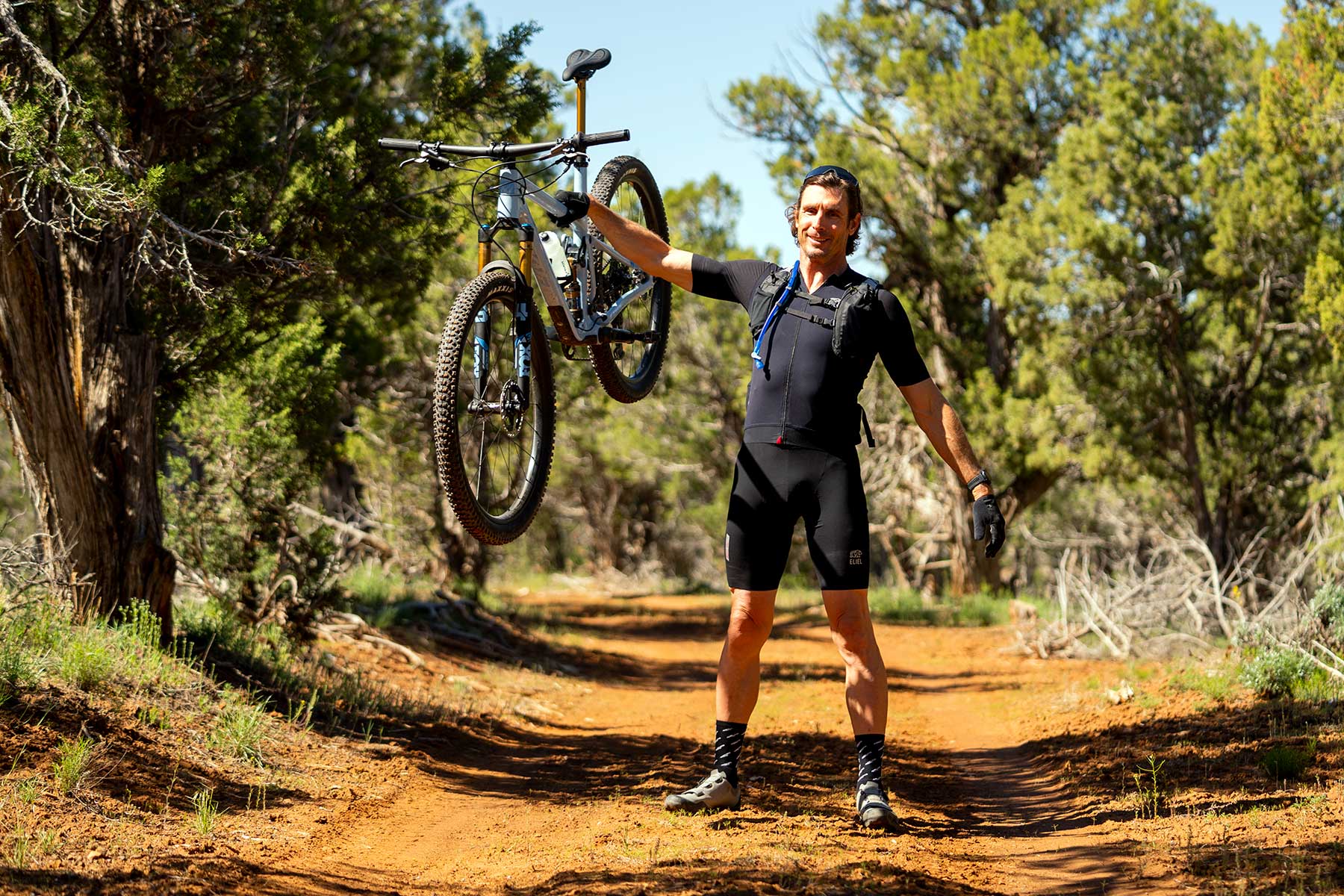rider holding the pivot mach 4SL xc mountain bike out with one arm