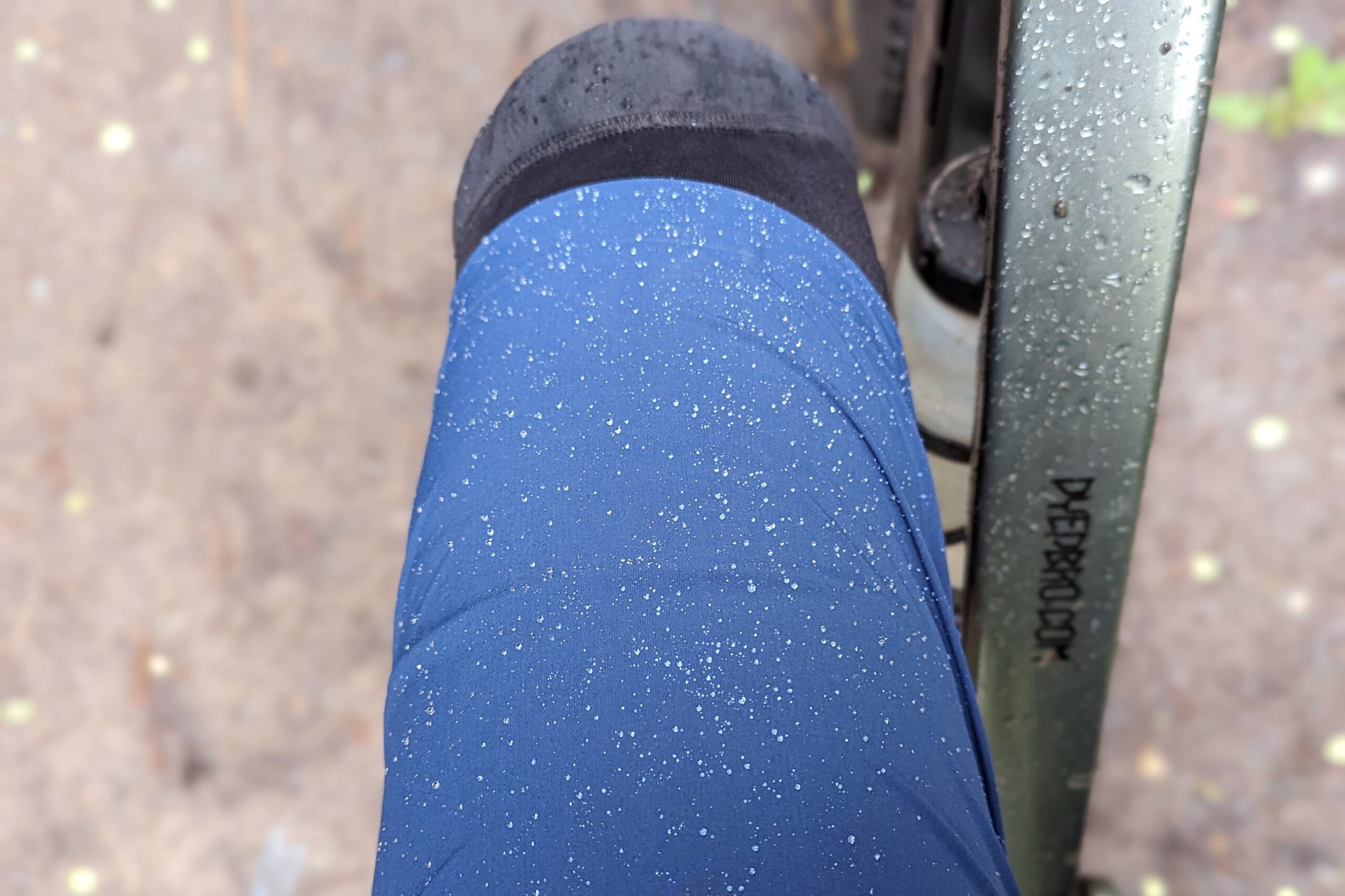 Water beading on the technical fabric of the 7Mesh Glidepath women's mountain bike shorts during a drizzly test ride