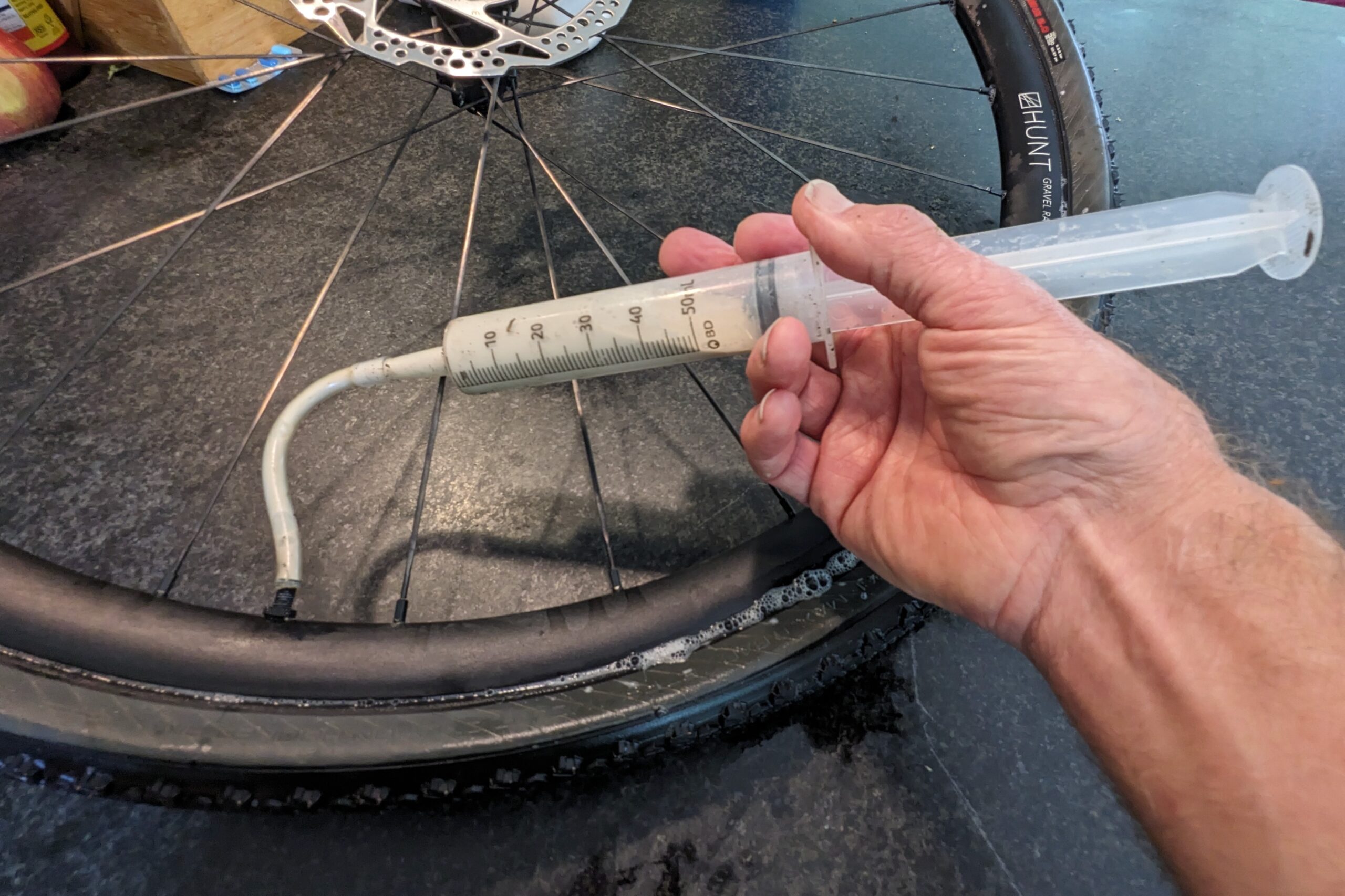 Adding sealant while seating a tubeless gravel bike tire
