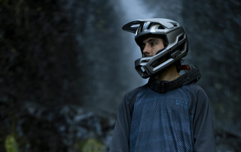 A man standing in the woods wearing a Bluegrass Vanguard Core helmet.