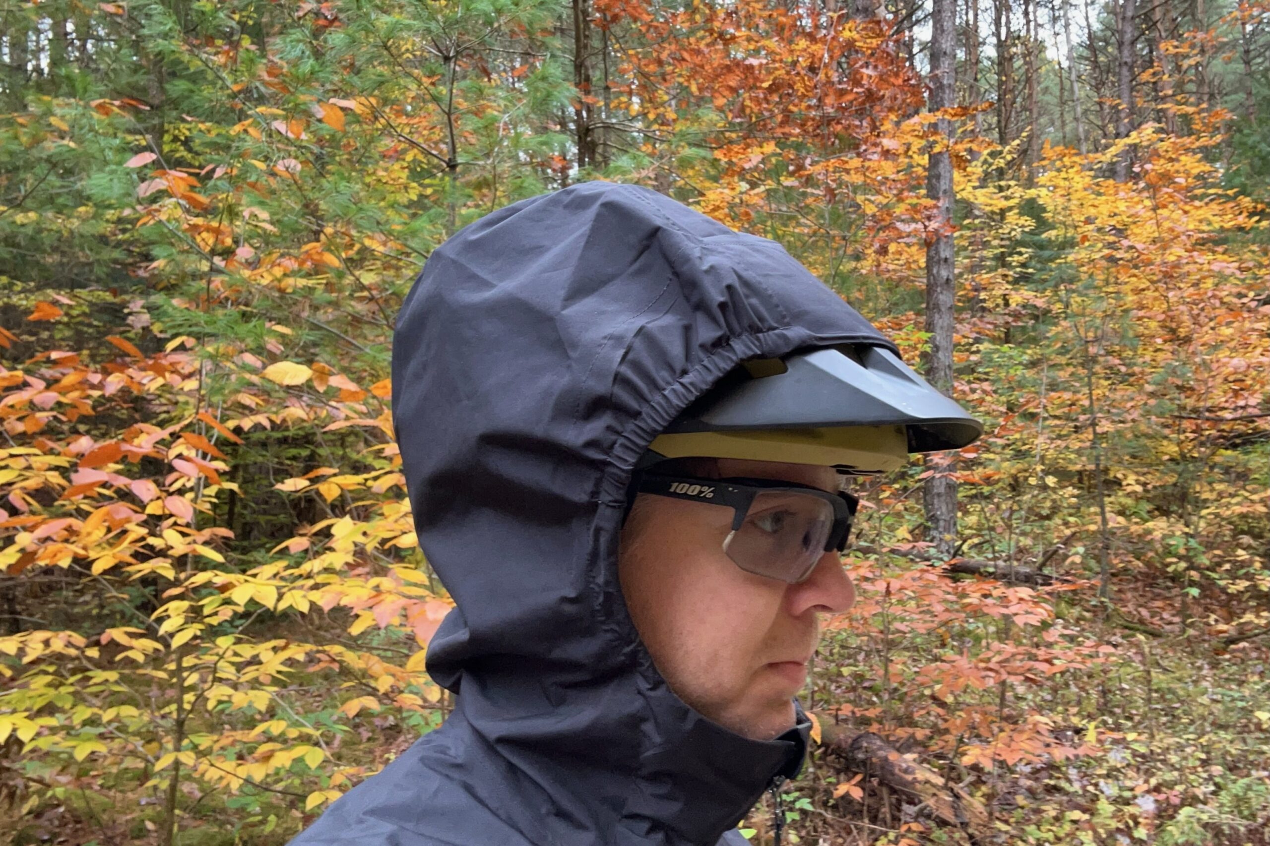 The hood of the Gorewear Endure jacket shown up over a mountain bike helmet