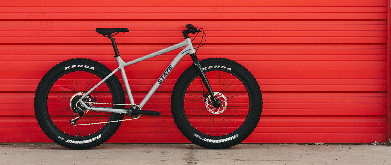 State Bicycle Co. 6061 Trail+ Fat Bike, an affordable alloy budget entry-level aluminum fatbike, grey on red