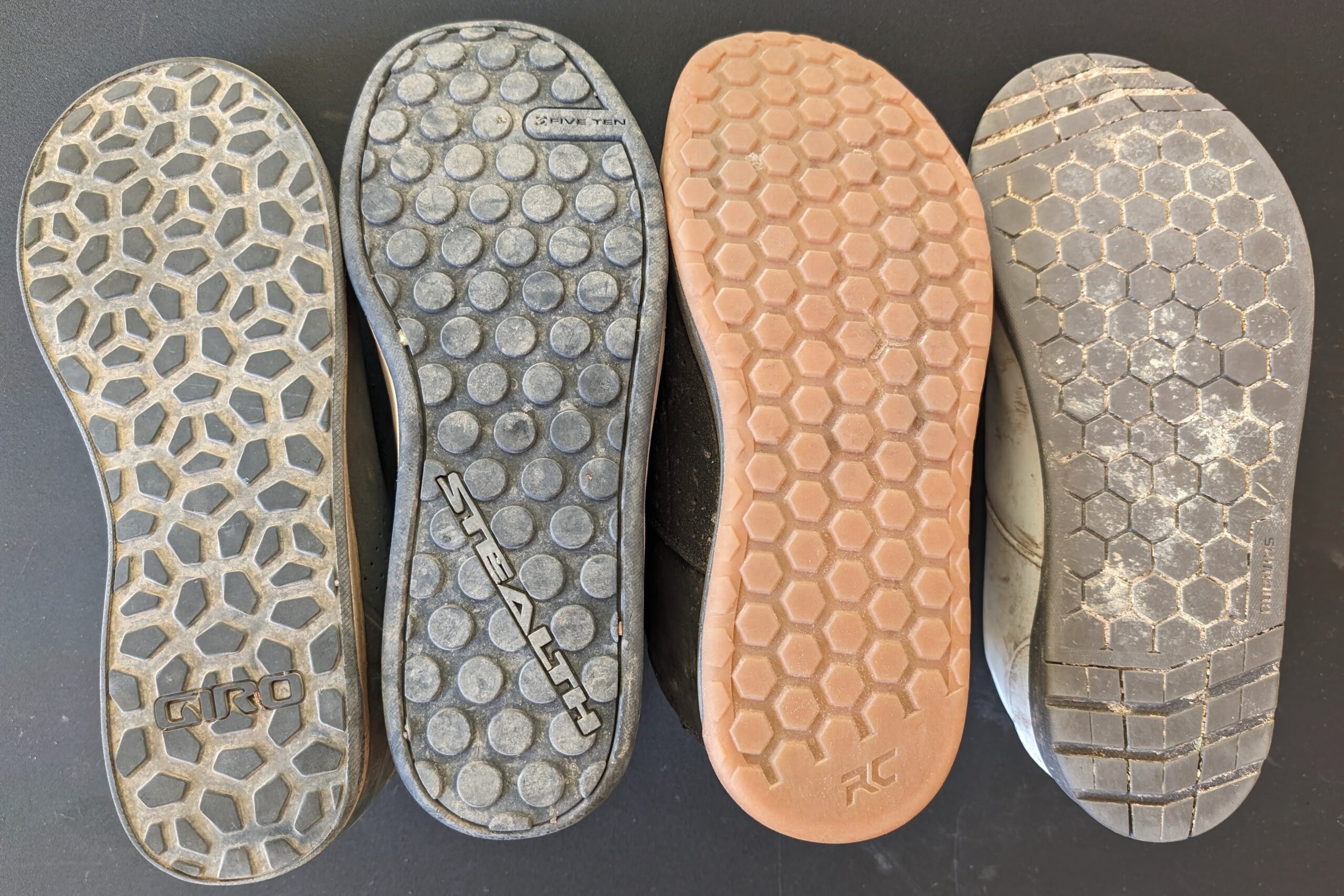 Comaprison shot of the soles of 4 flat pedal shoes