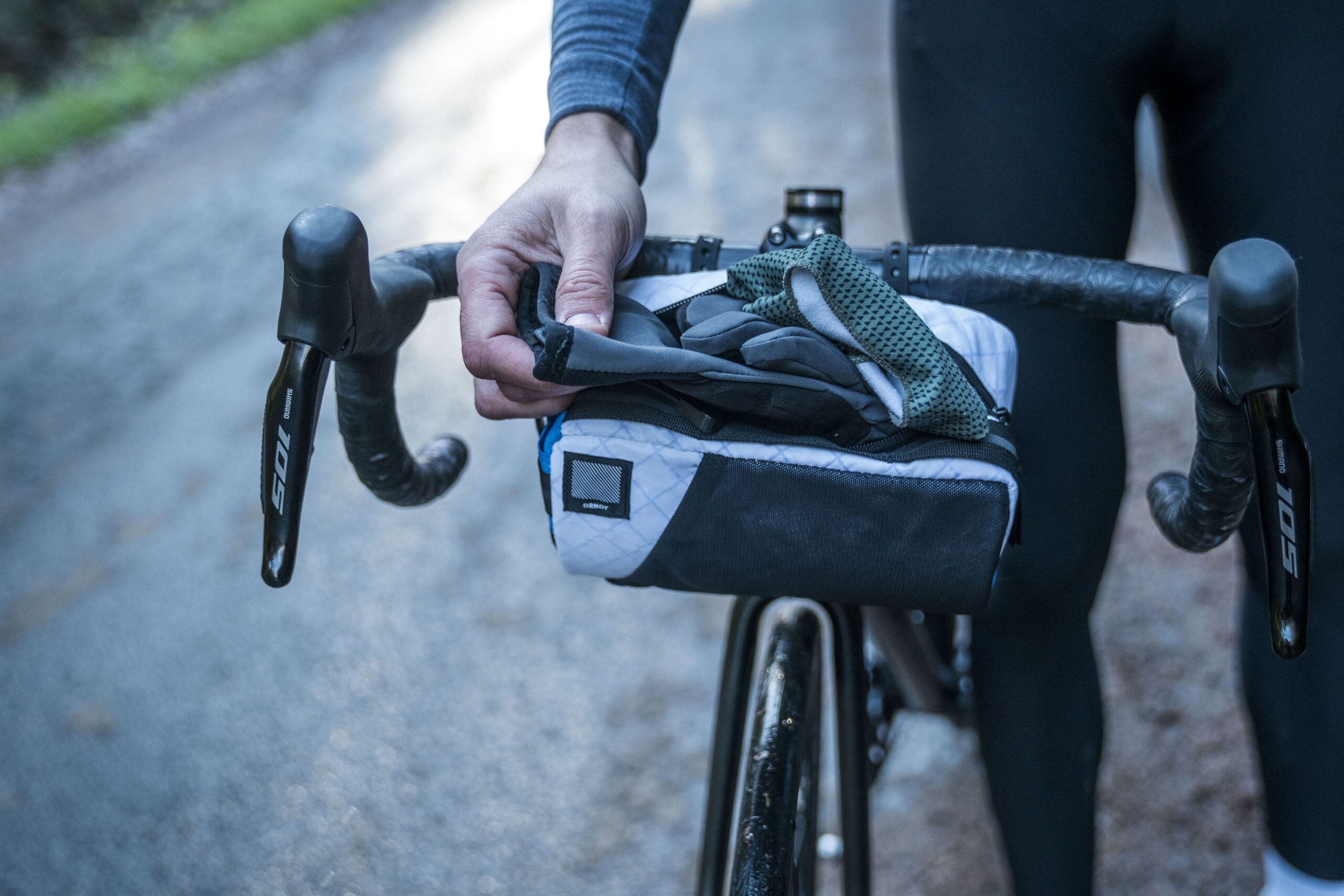 Pulling a pair of cycling gloves out of the Ornot Handlebar Bag