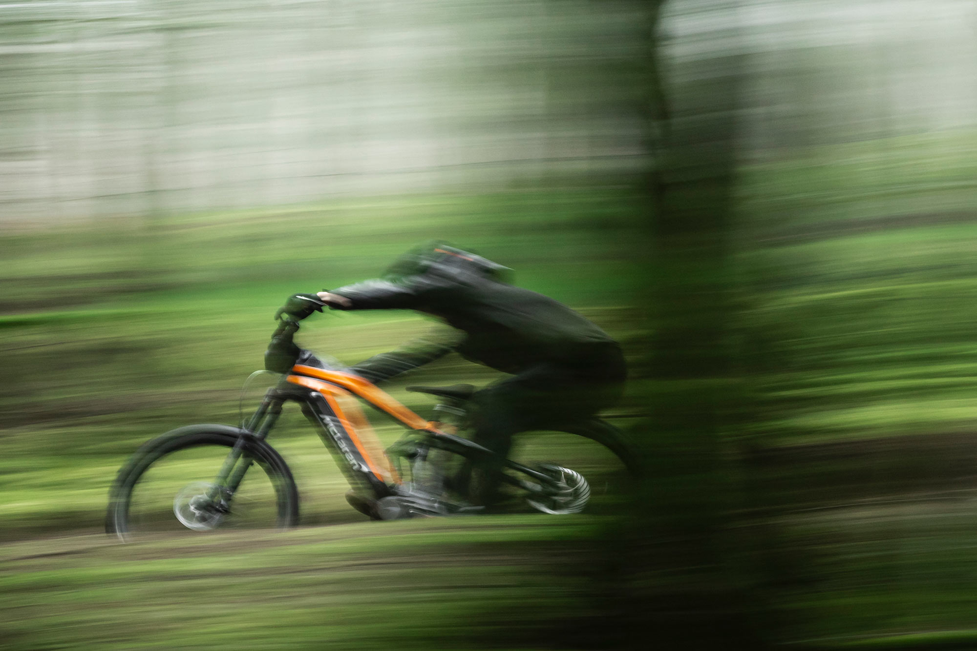 mclaren extreme 600 e-mountain bike shown riding fast in the woods