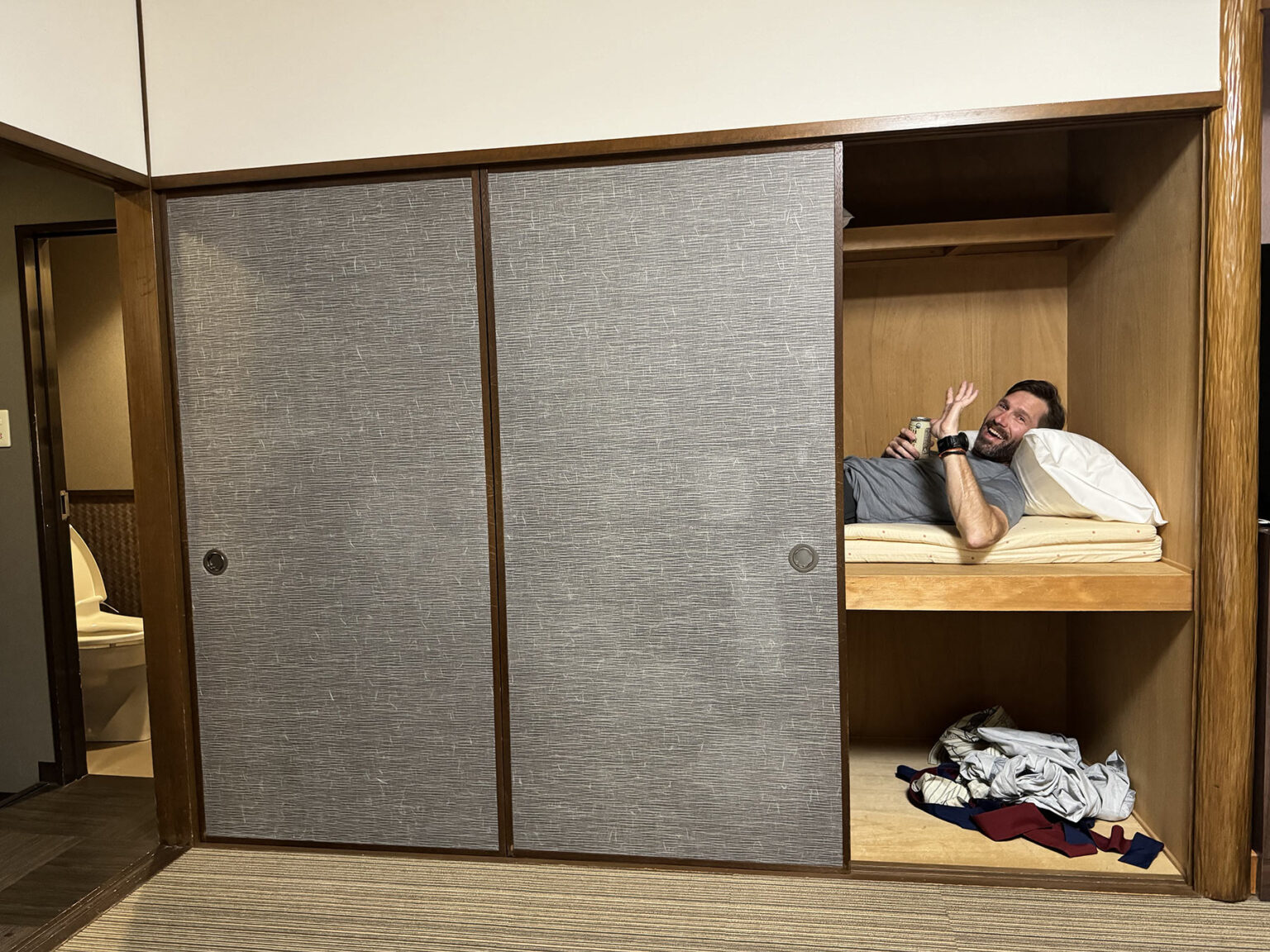 steve sleeping in closet in hotel in japan.