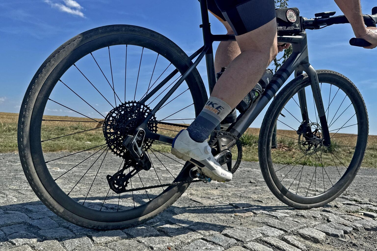 Merit Jumbo 750d big-wheeled carbon gravel bike, riding gravel cobbles