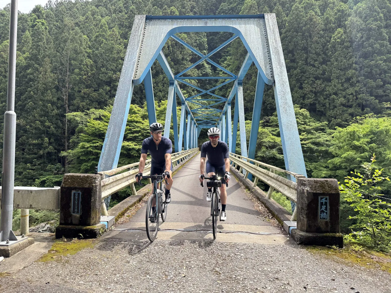 riders coming across a bridge wearing gore cycling kits.