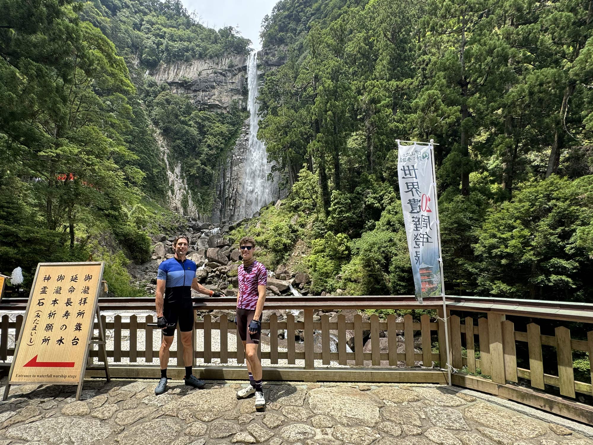 cyclists wearing gore kits standing in front of waterfall in japan.