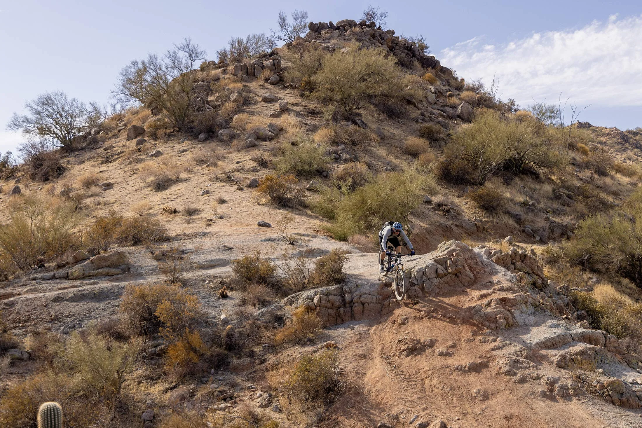 tyler riding the new race face turbine sl stem on a desert mountain bike trail.