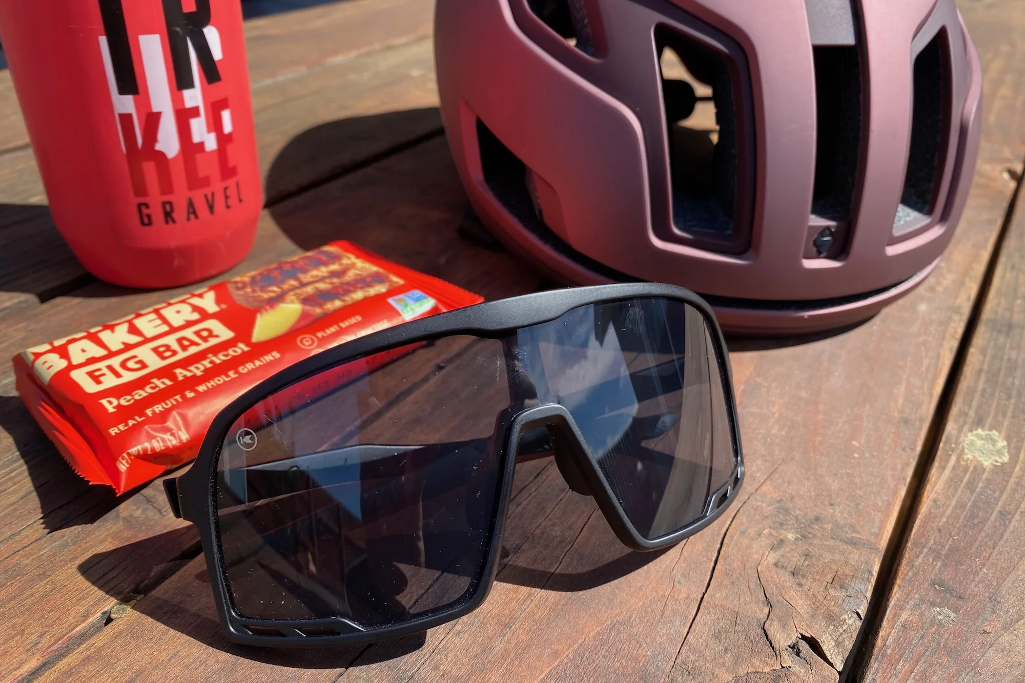 The Knockaround Campeones on a table with a bike helmet, snack, and waterbottle