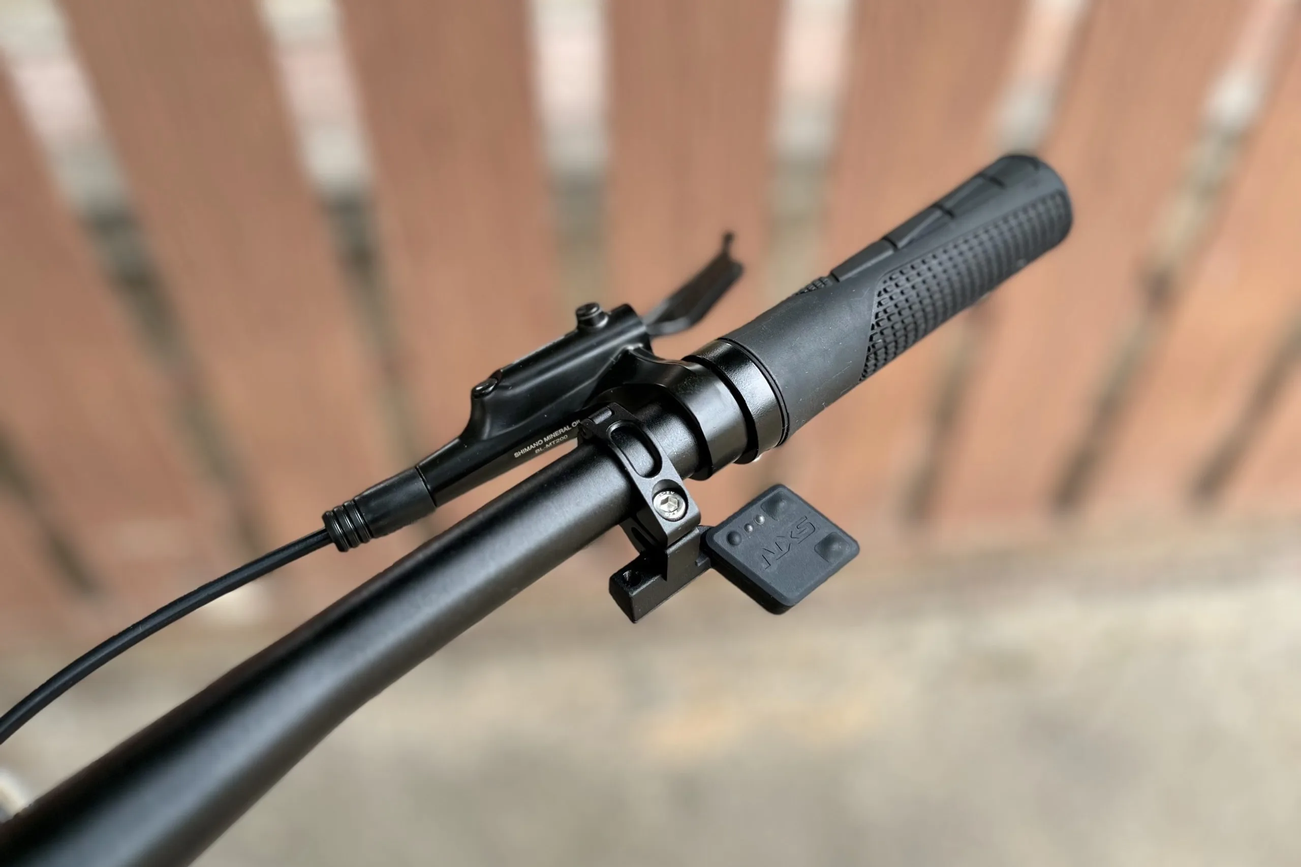 The NXS wireless shifter mounted on a handlebar