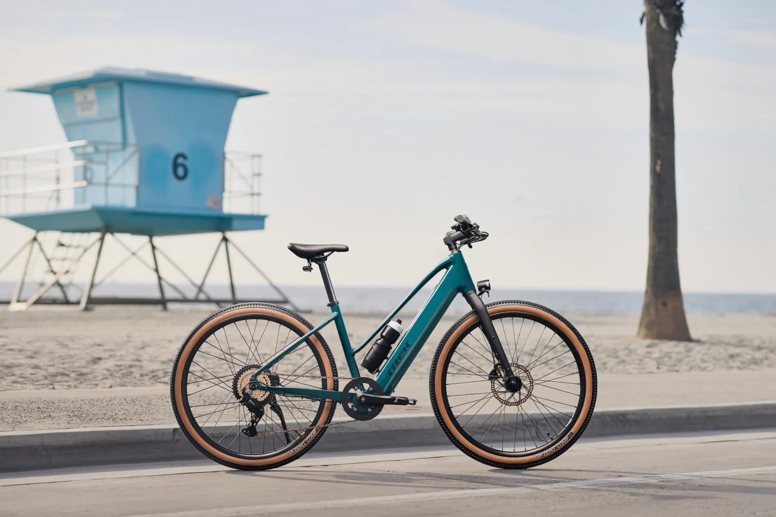 The midstep version of the Trek FX+ 1 parked on a bike patch by the beach