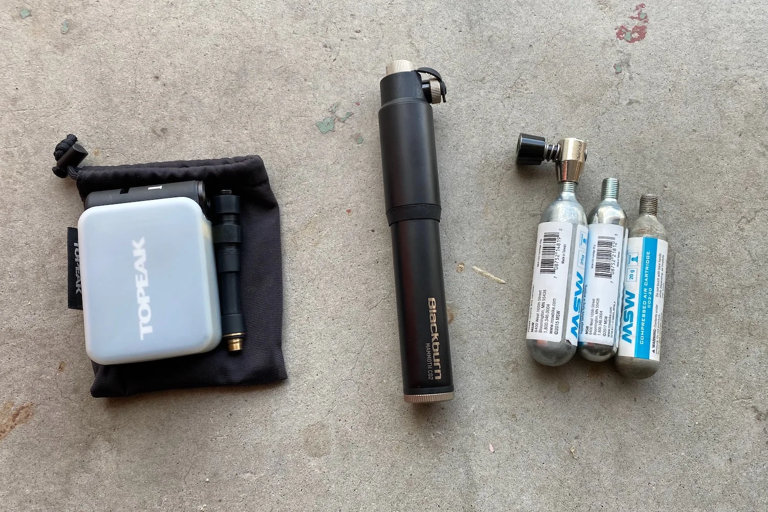 Comparing the size of the Topeak E-booster to a mini-pump and 3 CO2 cartridges