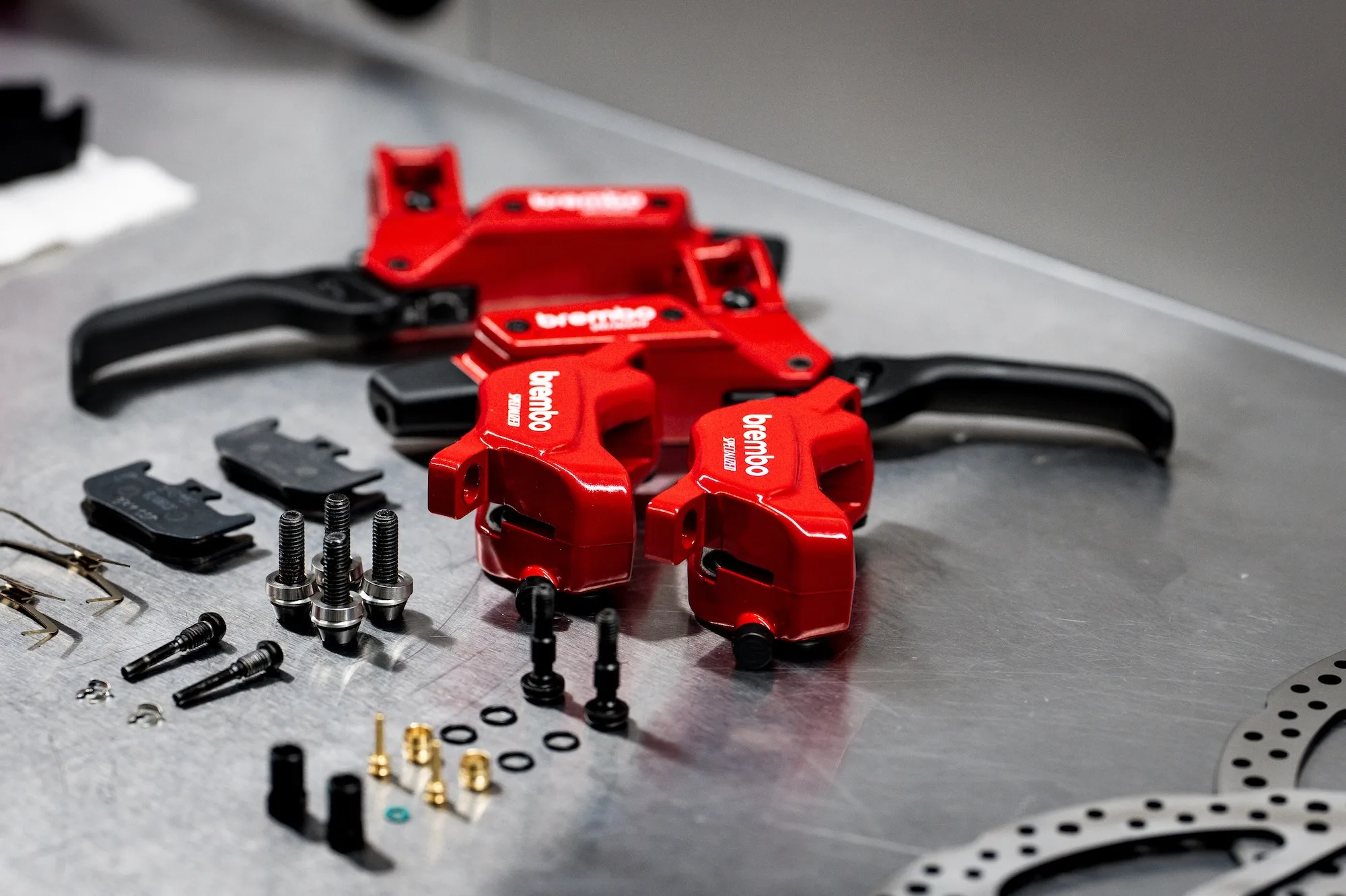 Un conjunto completo de frenos de bicicleta de montaña Brembo en un banco de trabajo esperando ser instalado en una bicicleta