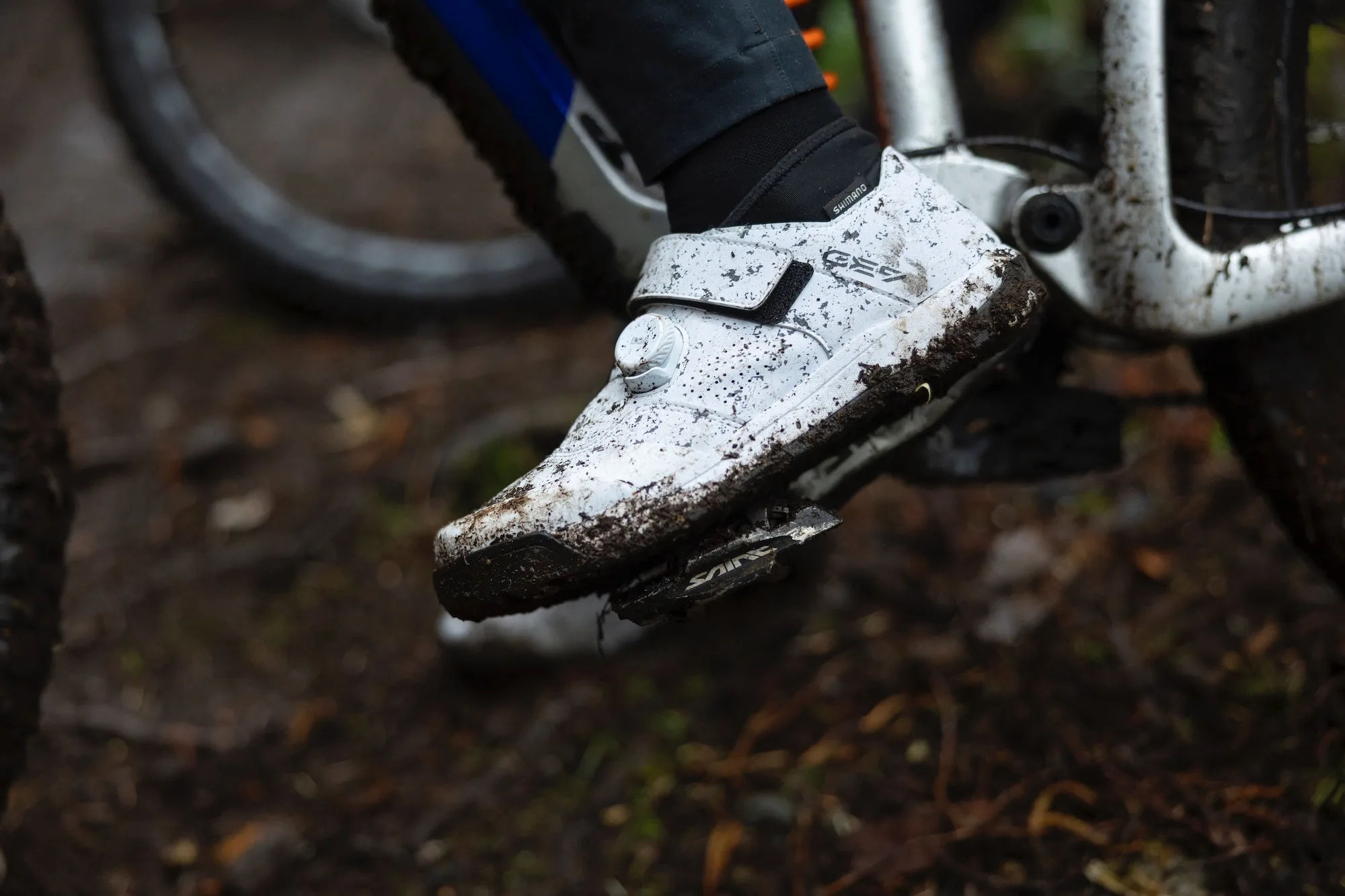 A pair of GE900HS shoes in white with mud on them