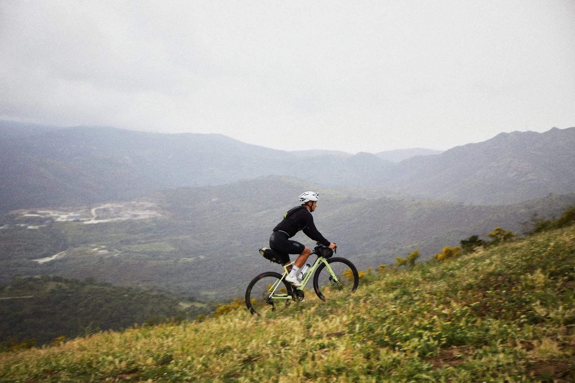 Una persona que montaba la bicicleta de grava de Orbea Terra con un par de bolsas de bicicletas adjuntas.