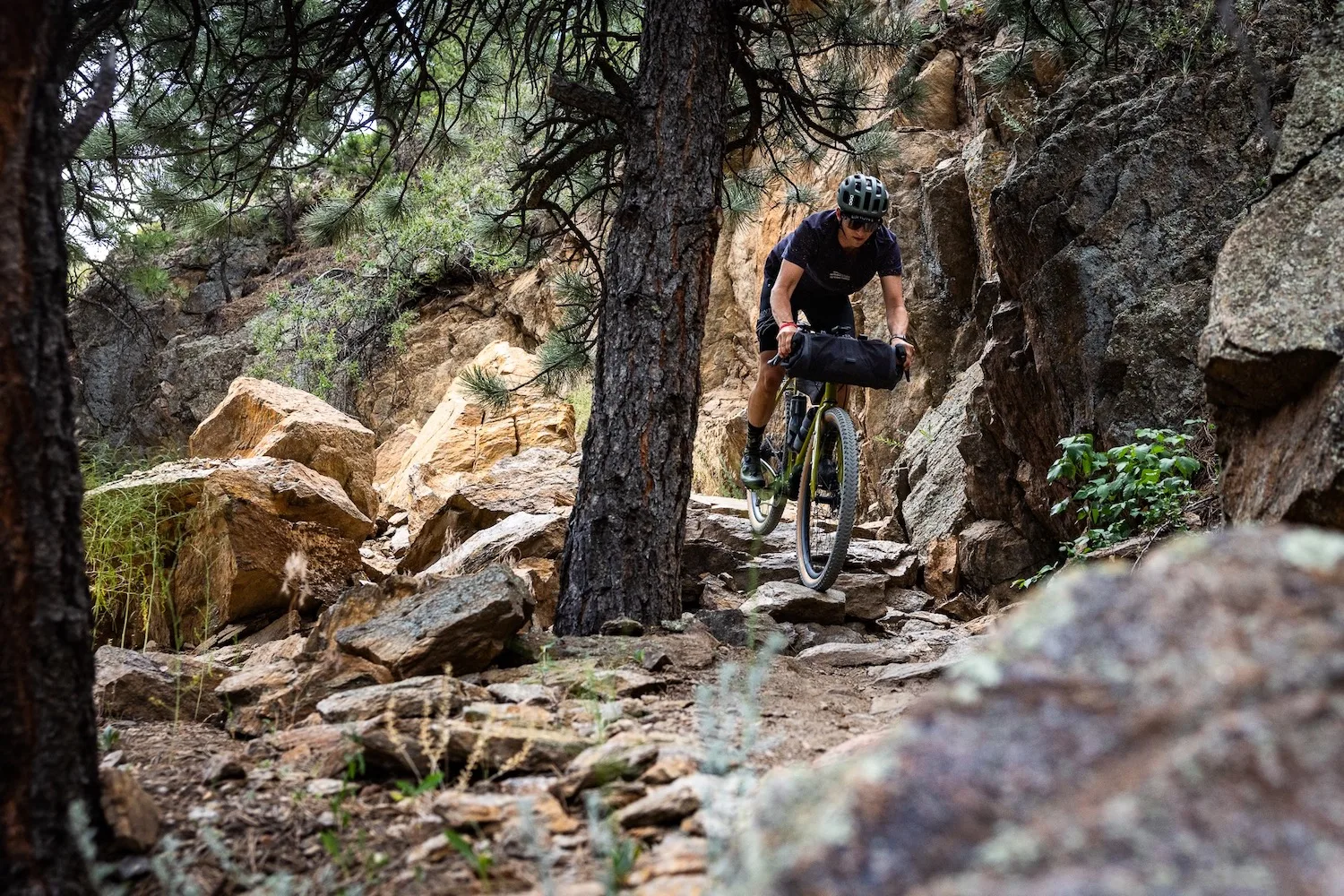 A rider on a gravel bike on a rough mountain bike trail.