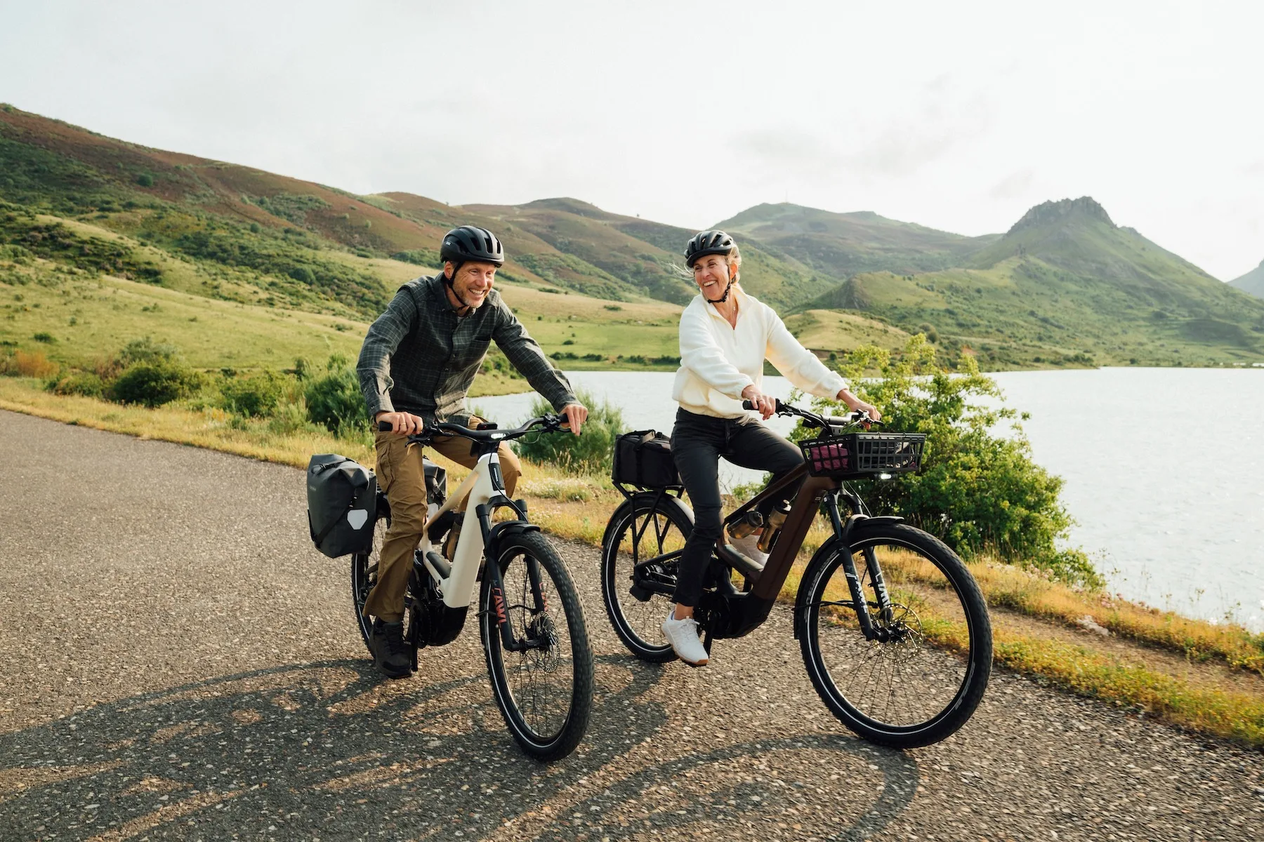 Una pareja que montaba bicicletas orbea muga junto a un pintoresco lago