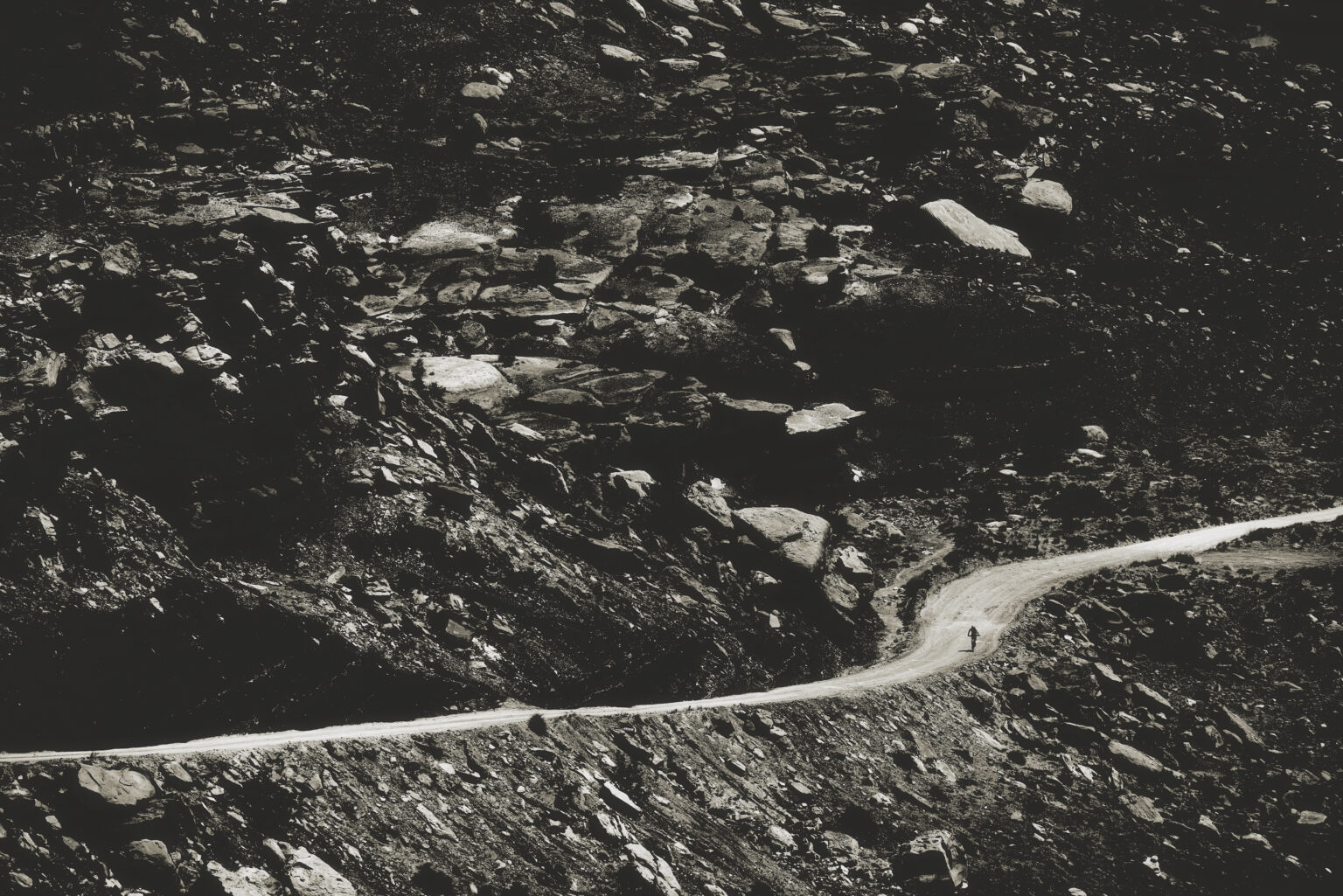 Hannah Otto riding a section of White Rim, zoomed out showing the rocky terrian