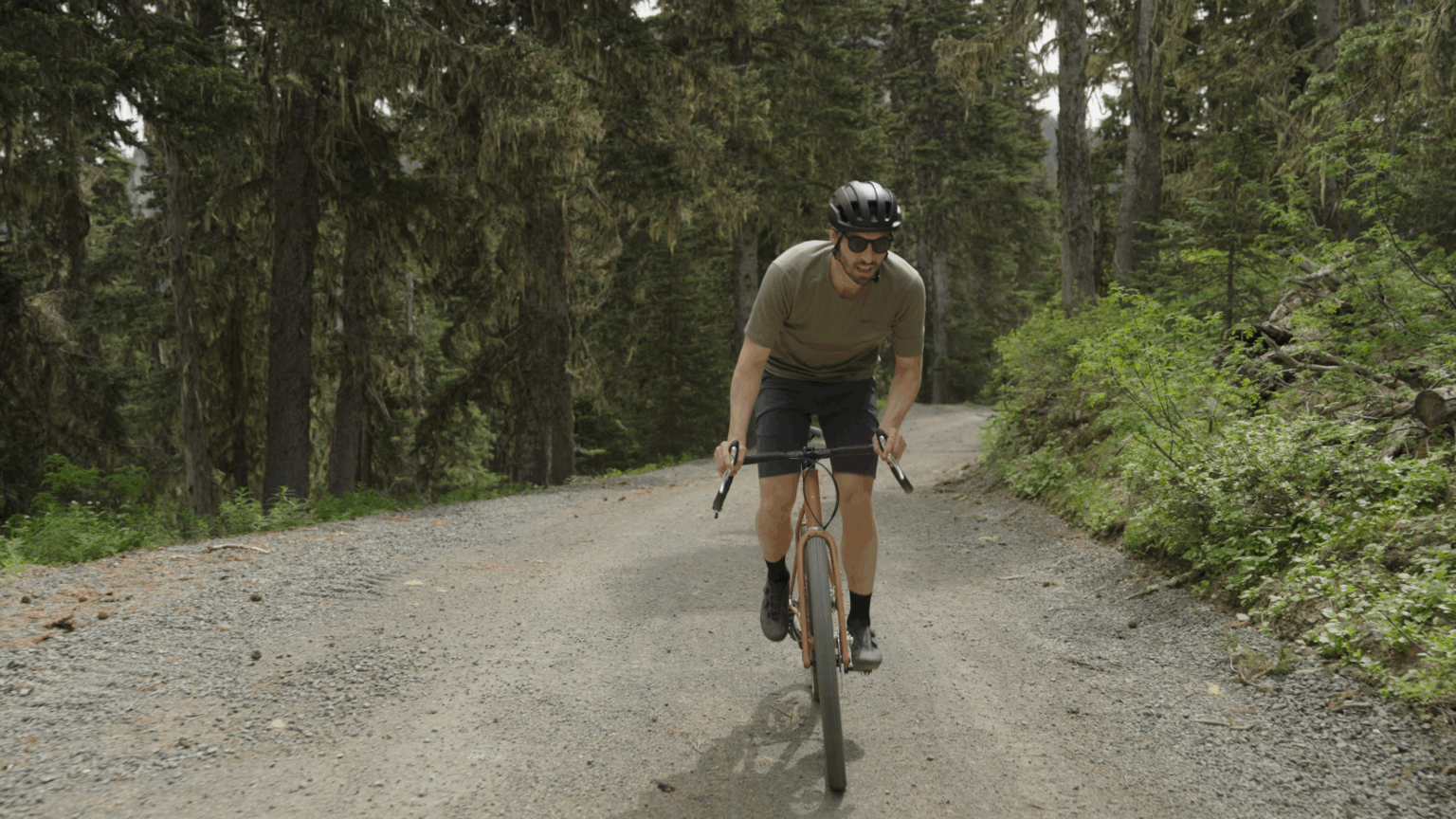 a rider on a Pine Cycles FRST on a gravel road in the woods