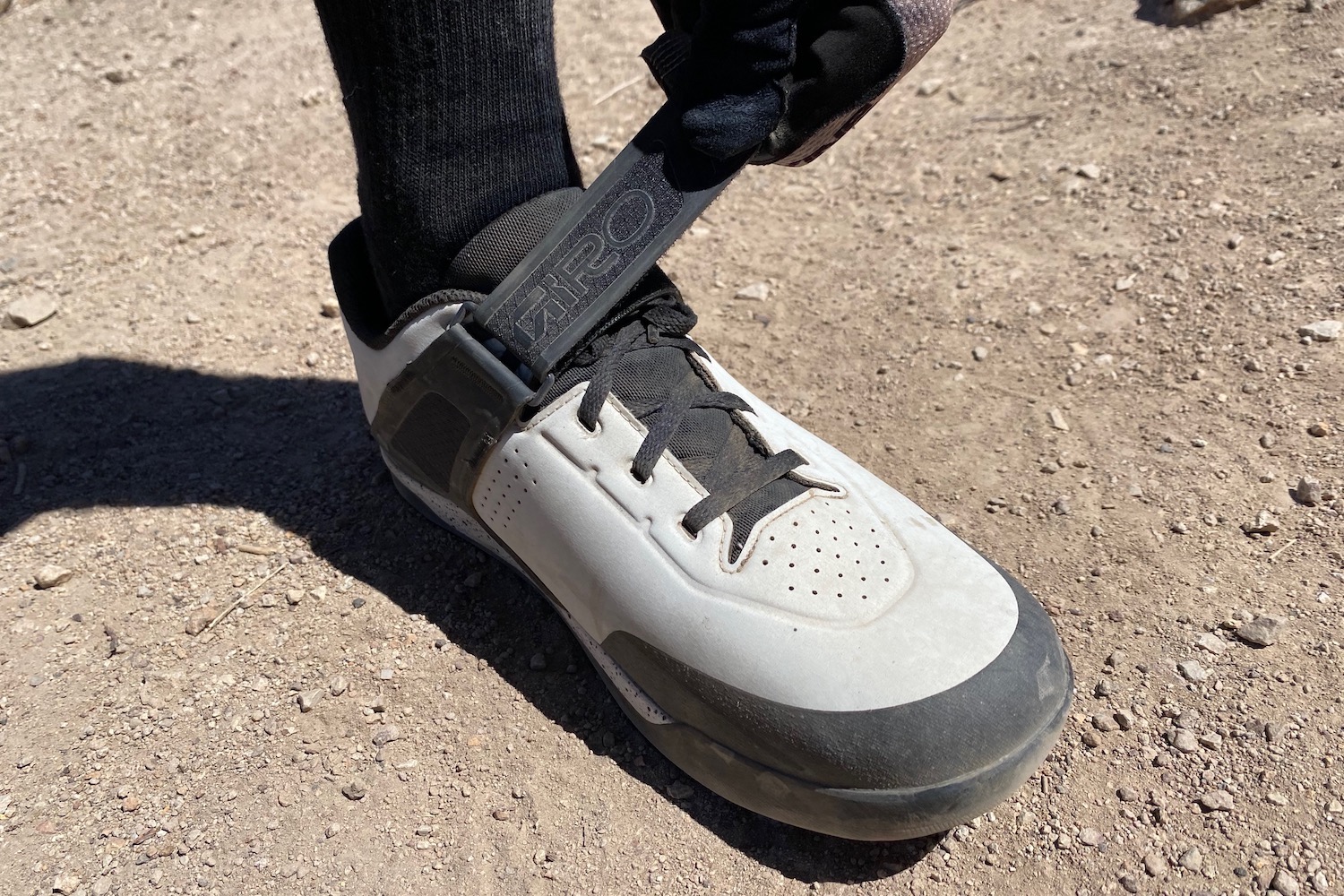 tightening the velcro strap on the Giro Chamber 3 to lock the heel down.