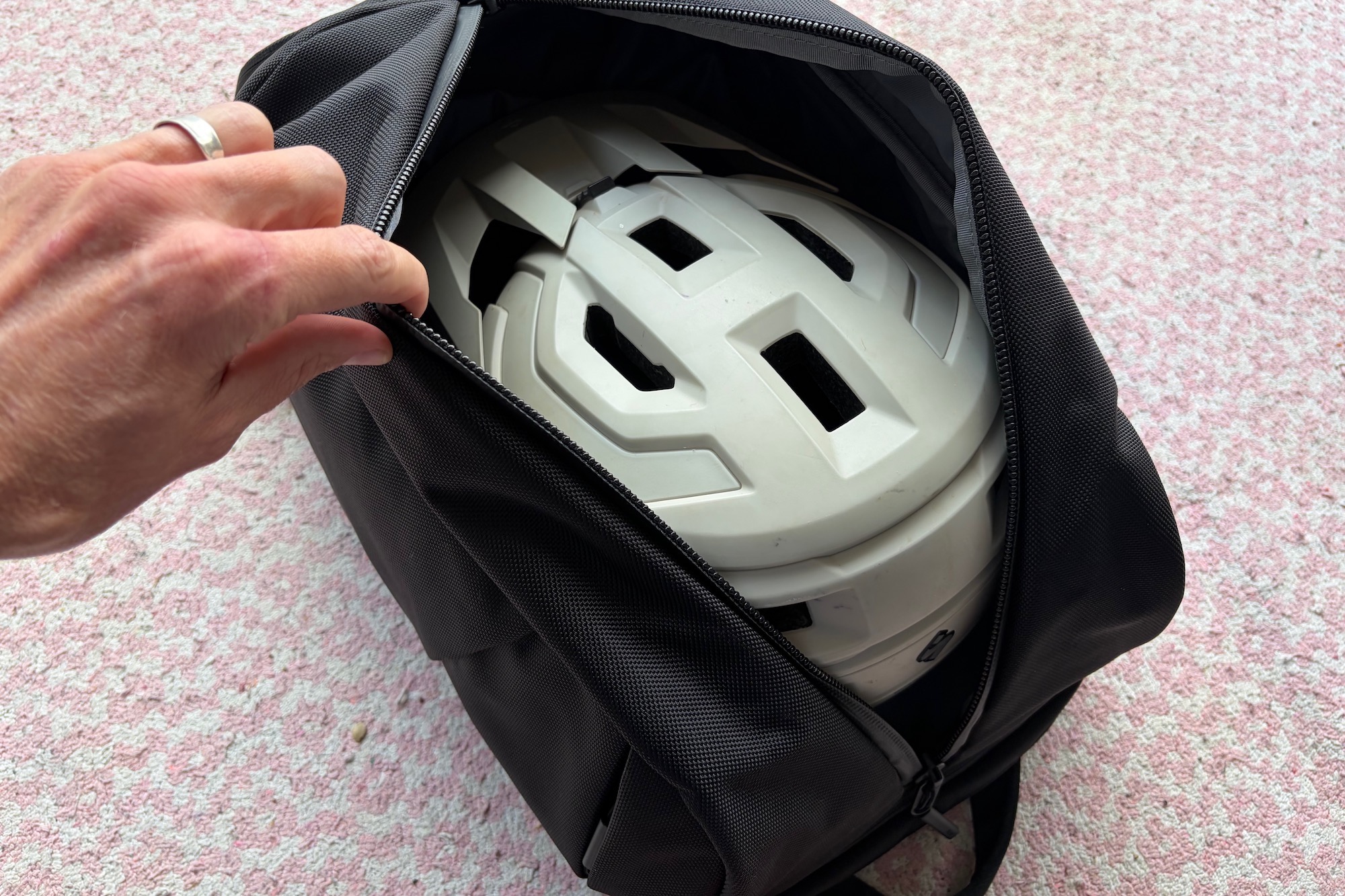 a mountain bike helmet inside the main compartment of the Duffel Pack 3