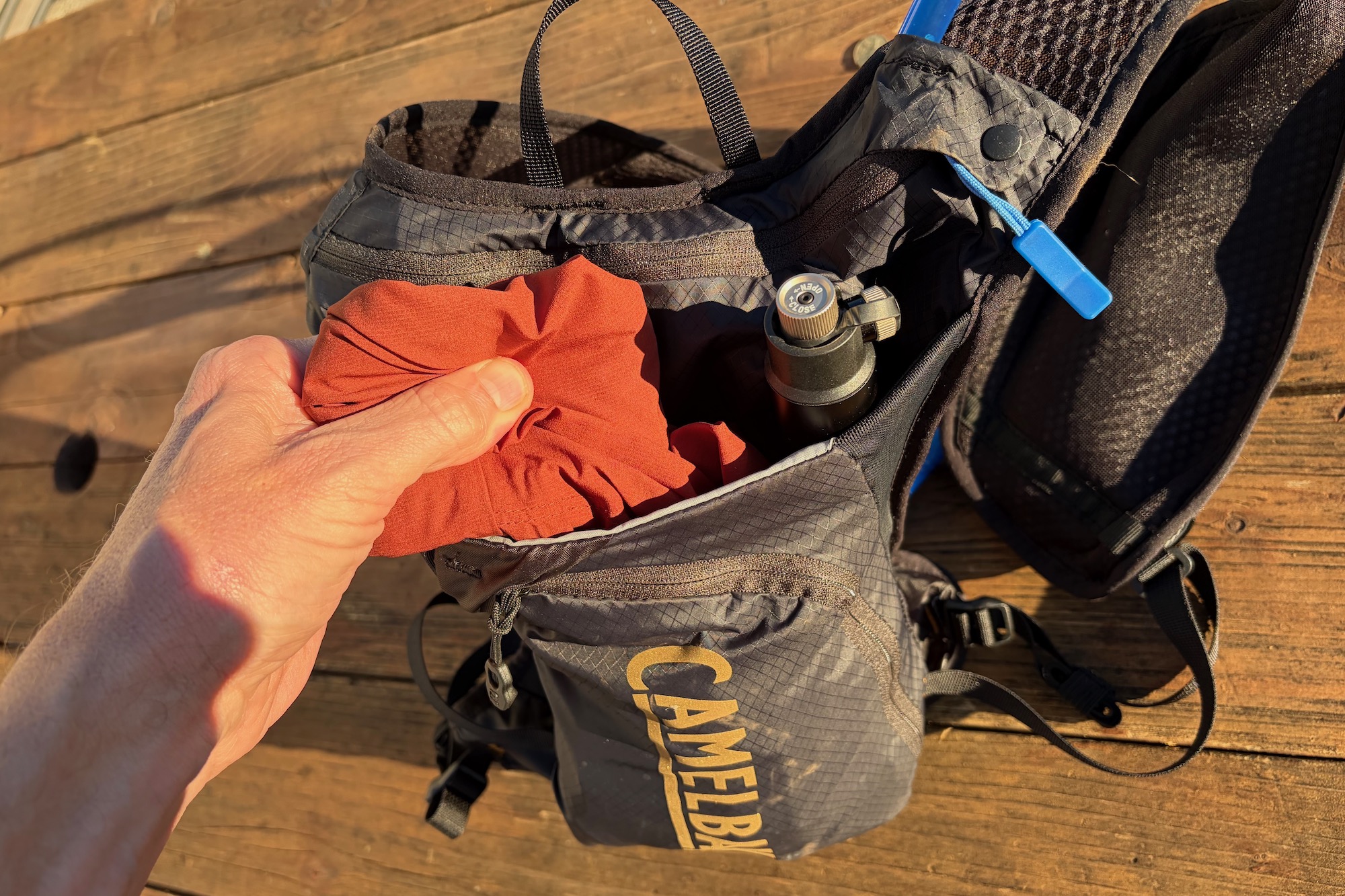 packing a vest and a hand pump in the storage sleeve of the Chase 4 vest.