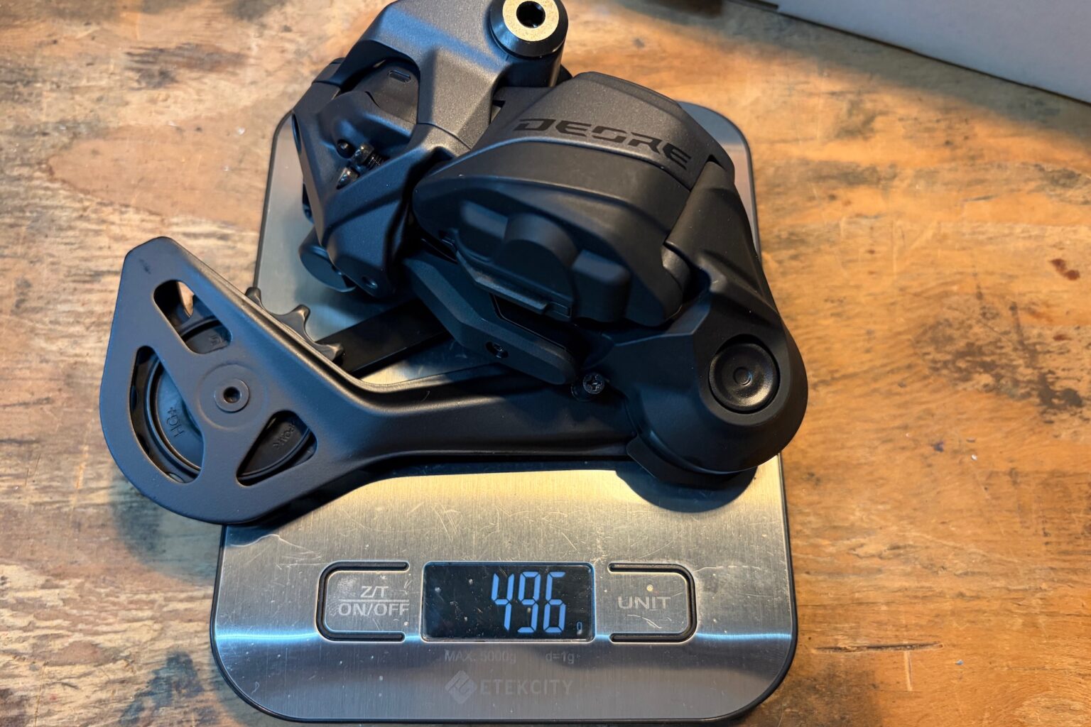 The Deore Di2 derailleur on a scale with a weight of 496 grams.