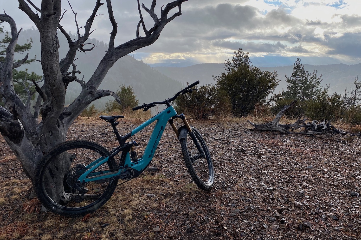 The Yeti LTe with the RockShox Reverb leaned against a tree on top of a mountain