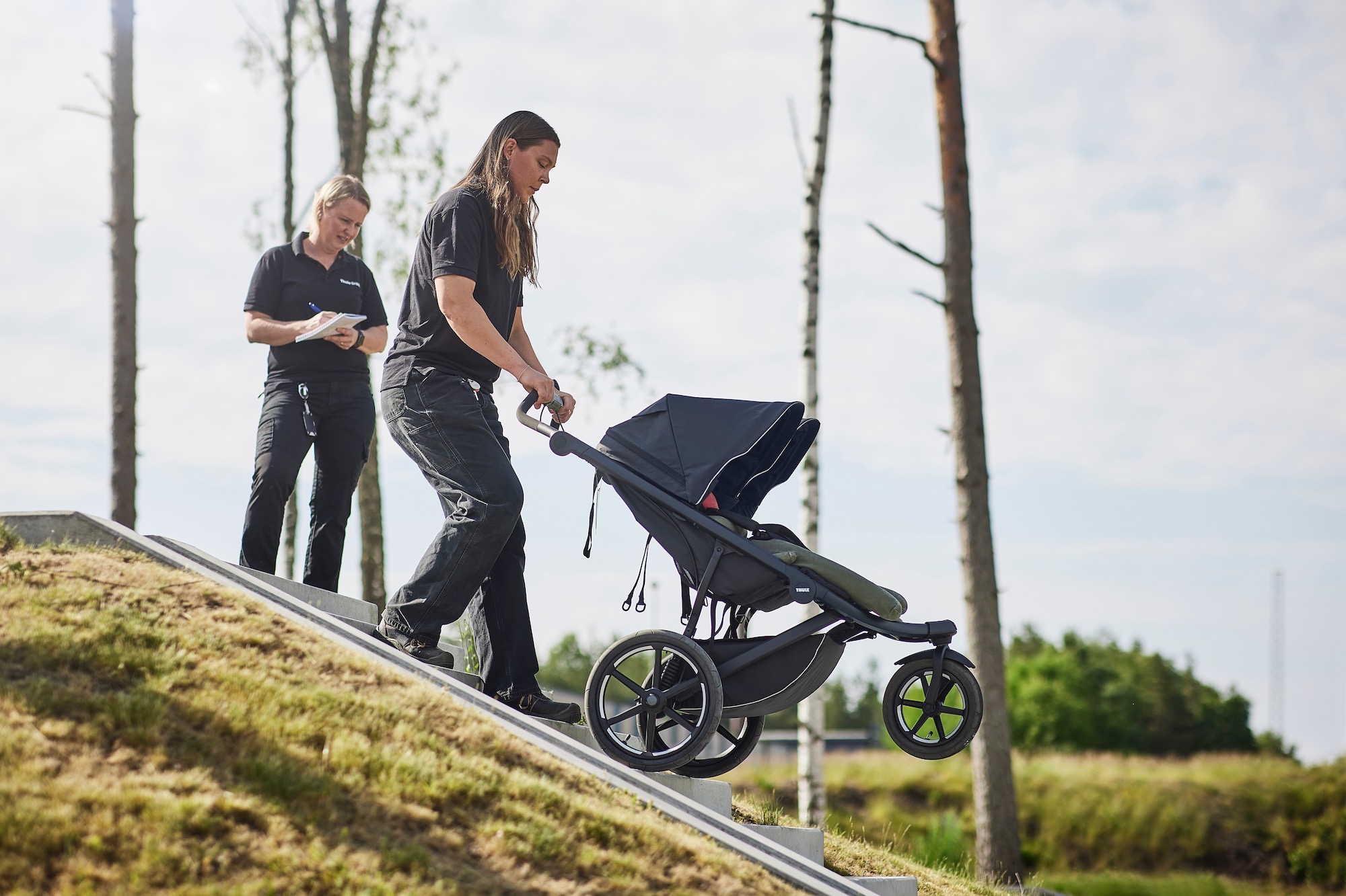 a woman rolling a stroller down a flight of stairs at Thule's outdoor test center.