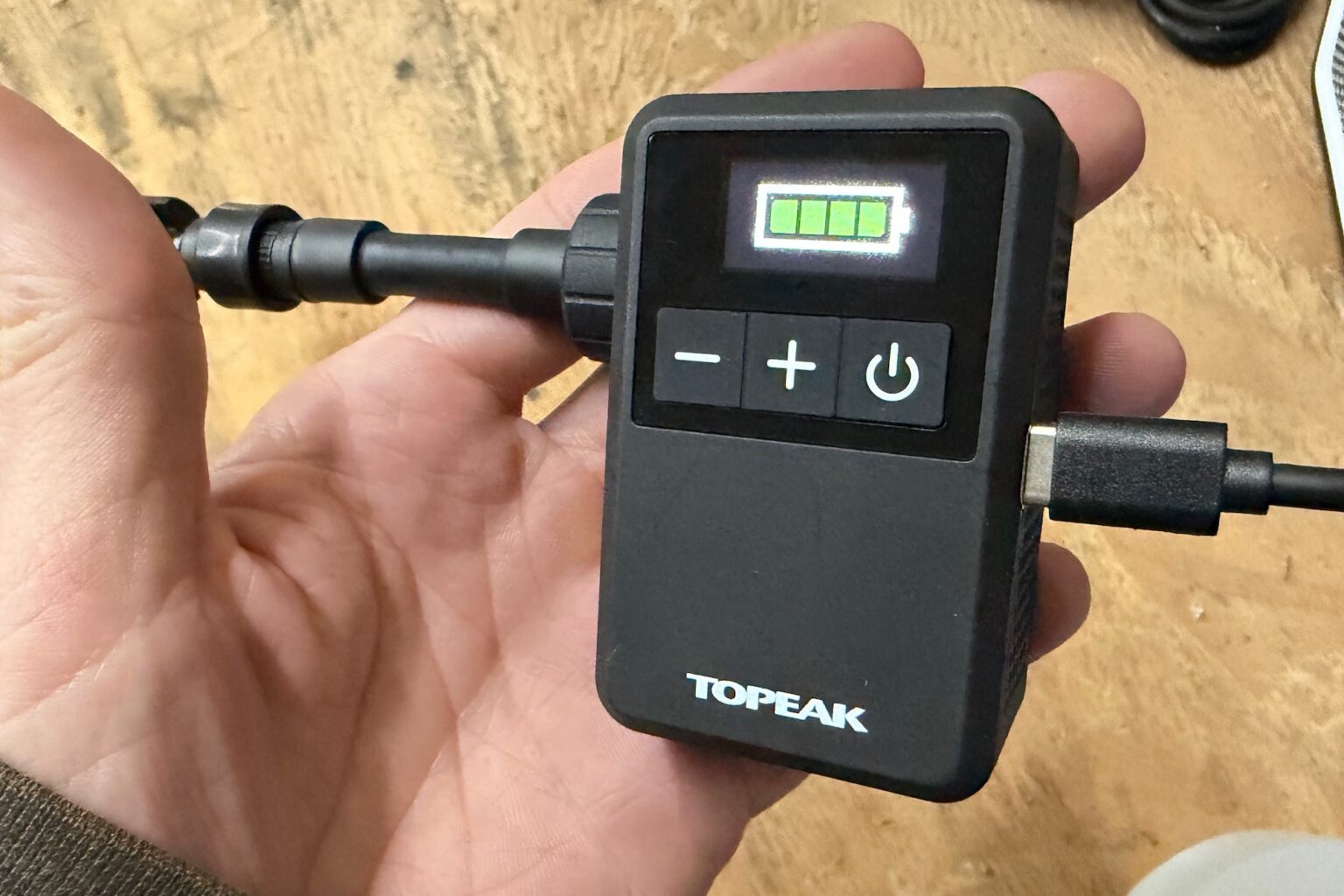 halding the Topeak E-Booster Mini while its charging