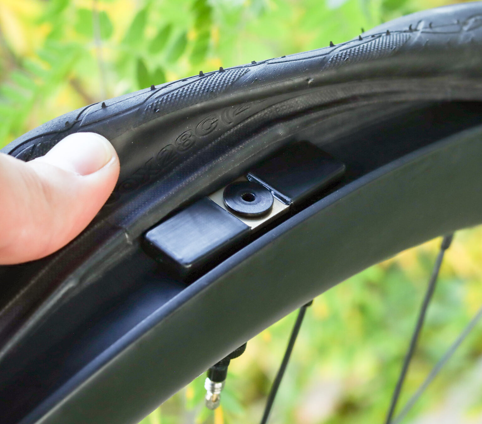 outrider TL mini wireless bicycle tire pressure monitor shown mounted inside a rim.