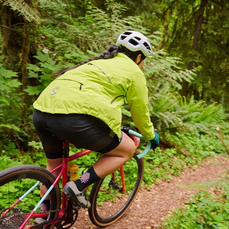 a woman riding the Showers Pass Century jacket