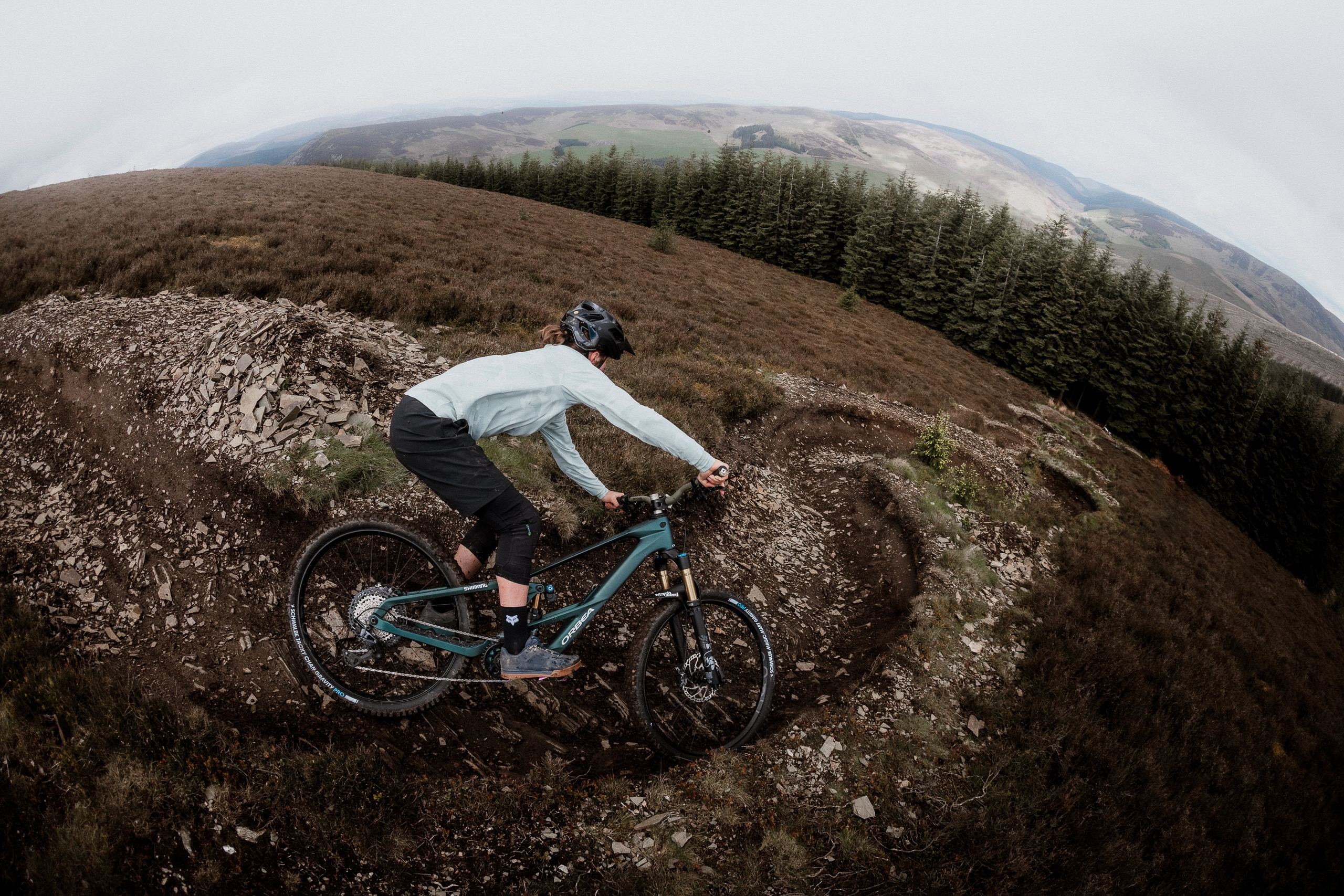a rider dropping into a series of bermed turn on the Orbea Wild eMTB