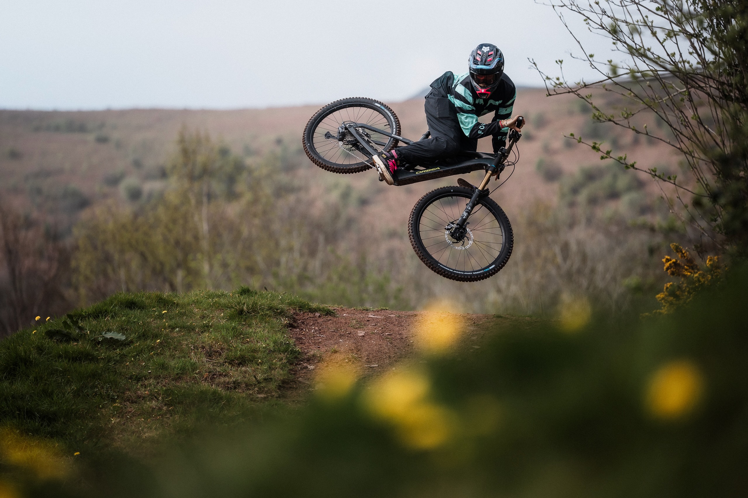 a rider hitting a jump and doing a tailwhip on the Orbea Wild eMTB