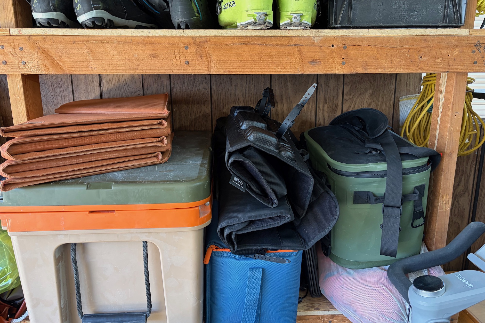 Evoc bagklappuden foldet sammen og opbevaret på en hylde med andre ting i en garage