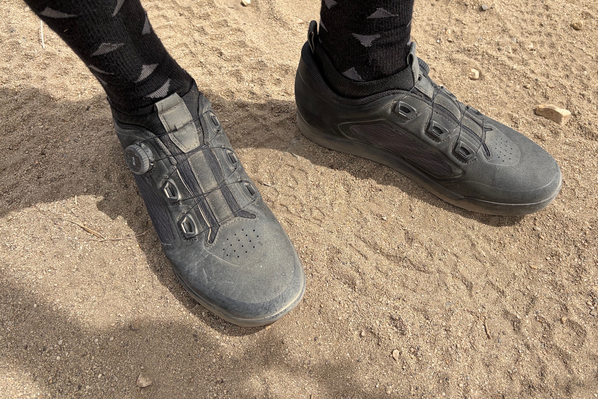 standing on some sandy soil wearing the Giro Chamber Trail shoes