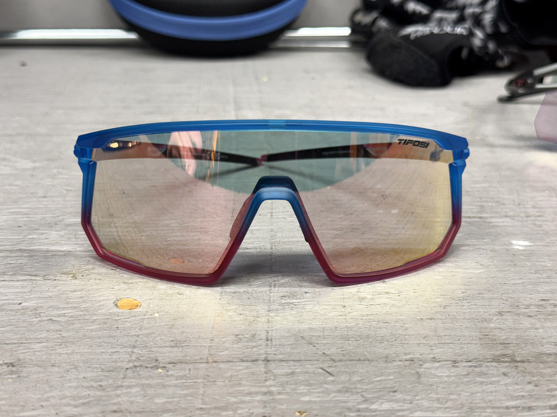 tifosi moab sunglasses with pink fototec lenses on a workbench.
