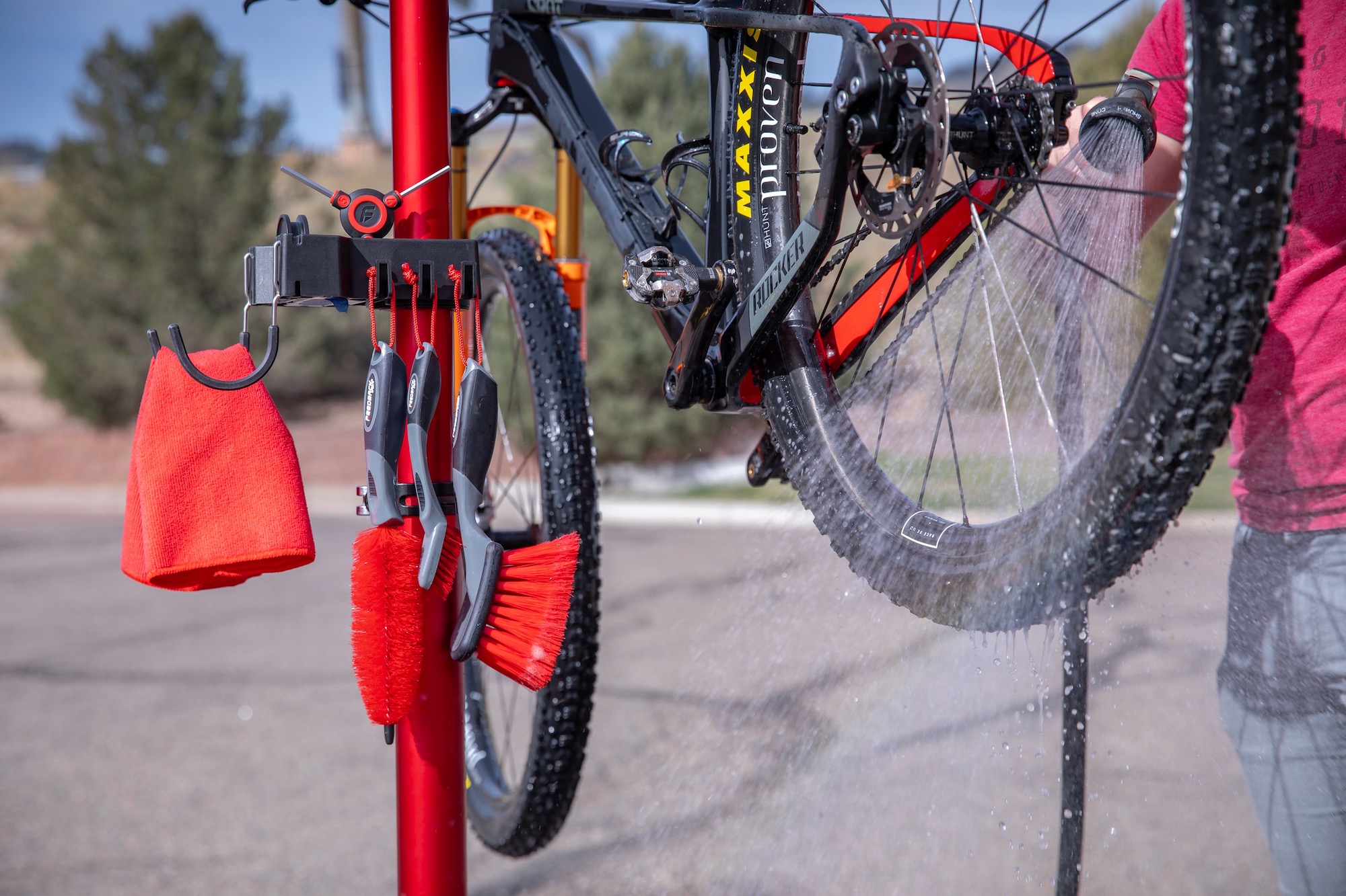 a person washing a bike on a work stand with the brush bar kit.